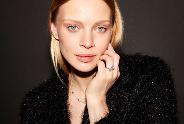 Frau trägt Toi-et-Moi-Ring aus Roségold mit blauem und hellem Edelstein, eleganter Studio-Look