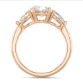 Trilogy ring with a 3.00 carat oval diamond with side pear diamonds of 0.35 carat each in red gold