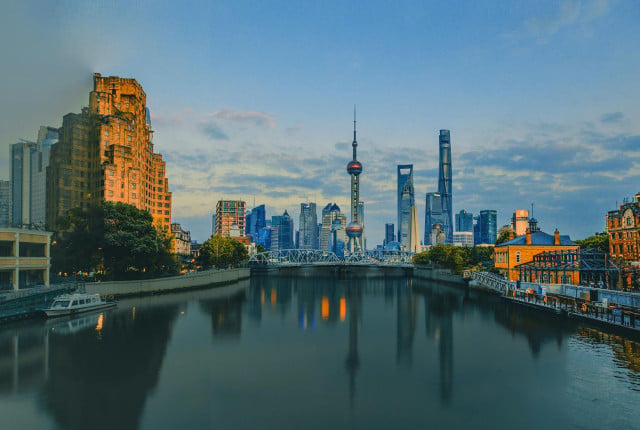 Shanghai skyline at dusk over the Huangpu River, with Oriental Pearl Tower and modern skyscrapers