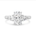 Anillo trilogía con un diamante oval de 3,00 quilates y diamantes pera laterales de 0,35 quilates cada uno en oro blanco