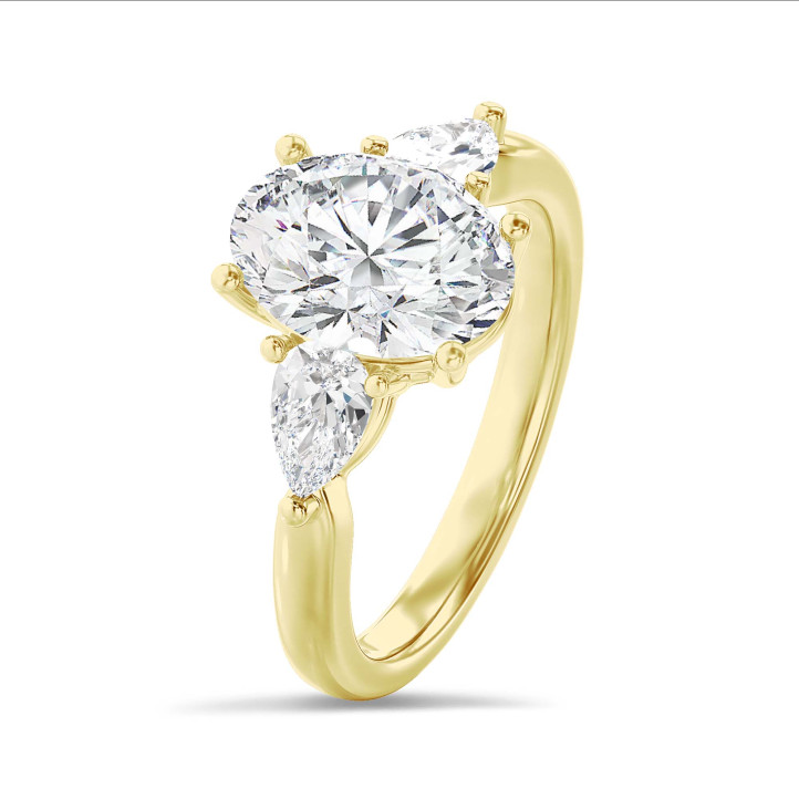 Anillo trilogía con un diamante oval de 3,00 quilates y diamantes pera laterales de 0,35 quilates cada uno en oro amarillo