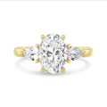 Anillo trilogía con un diamante oval de 3,00 quilates y diamantes pera laterales de 0,35 quilates cada uno en oro amarillo