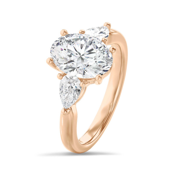 Bague trilogie en or rouge avec un diamant ovale de 3.00 carats et deux diamants en forme de poire de 0.35 carat chacun.
