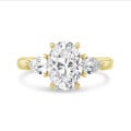 Anello trilogy con diamante ovale da 3,00 carati e diamanti a goccia laterali da 0,35 carati ciascuno in oro giallo
