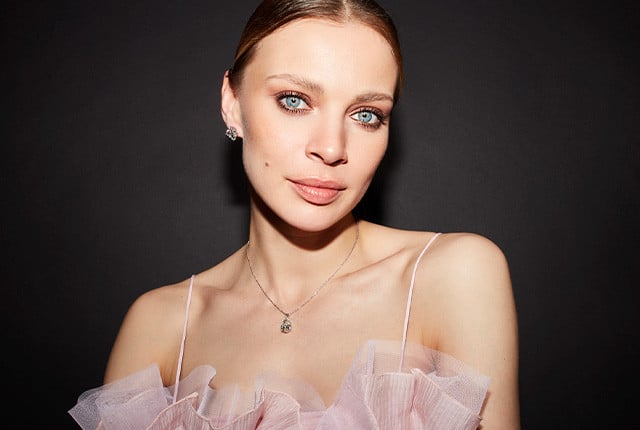 Modella con collana in oro bianco e pendente con diamante, orecchini a punto luce in stile elegante