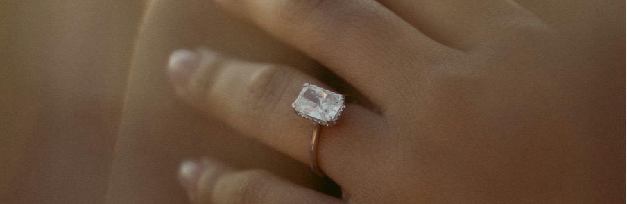 Frau trägt einen weißen Diamantring im Smaragdschliff