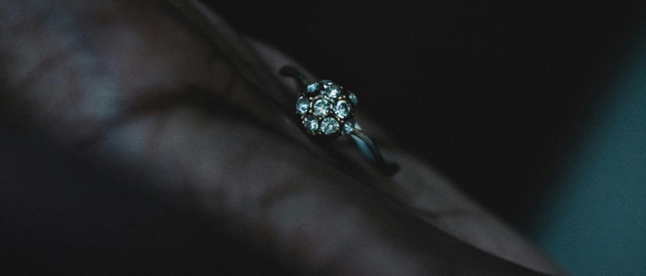 Bague en diamant sur une main dans le noir