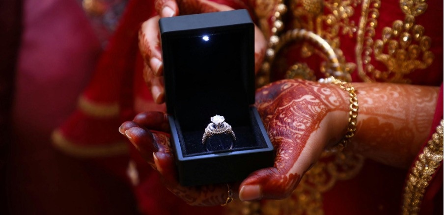Femme indienne présentant une bague de fiançailles en diamant dans une boîte en velours
