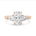 Trilogie ring met een 3.00 karaat ovale diamant met zijdelingse peer diamanten van elk 0.35 karaat in roodgoud