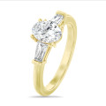 Laboratuvarda üretilmiş oval elmas ve laboratuvarda üretilmiş konik baget taşlarla süslenmiş, sarı altın 2,00 karatlık üçlü yüzük
